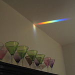 A prism integrated in a window across the room throws a rainbow when the sun is shining. (Champagne glasses by Ulla Forsell)